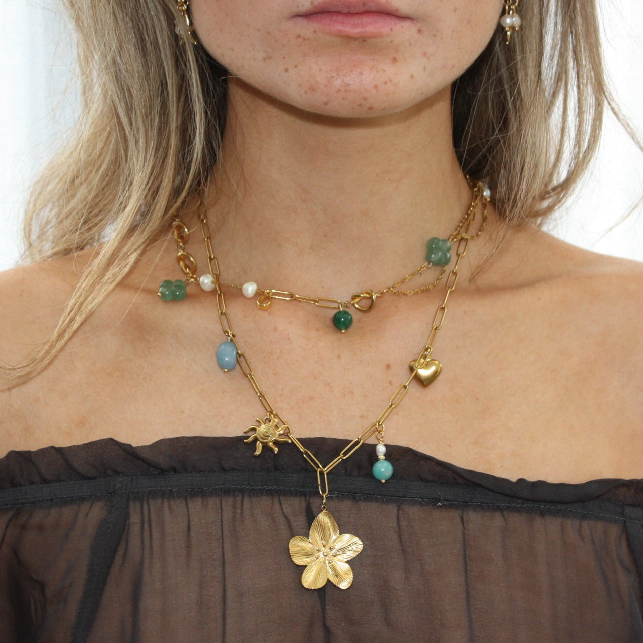 Layered Custom Charm Necklace displaying a flower charm and multiple colourful stones, enhancing the chic style.