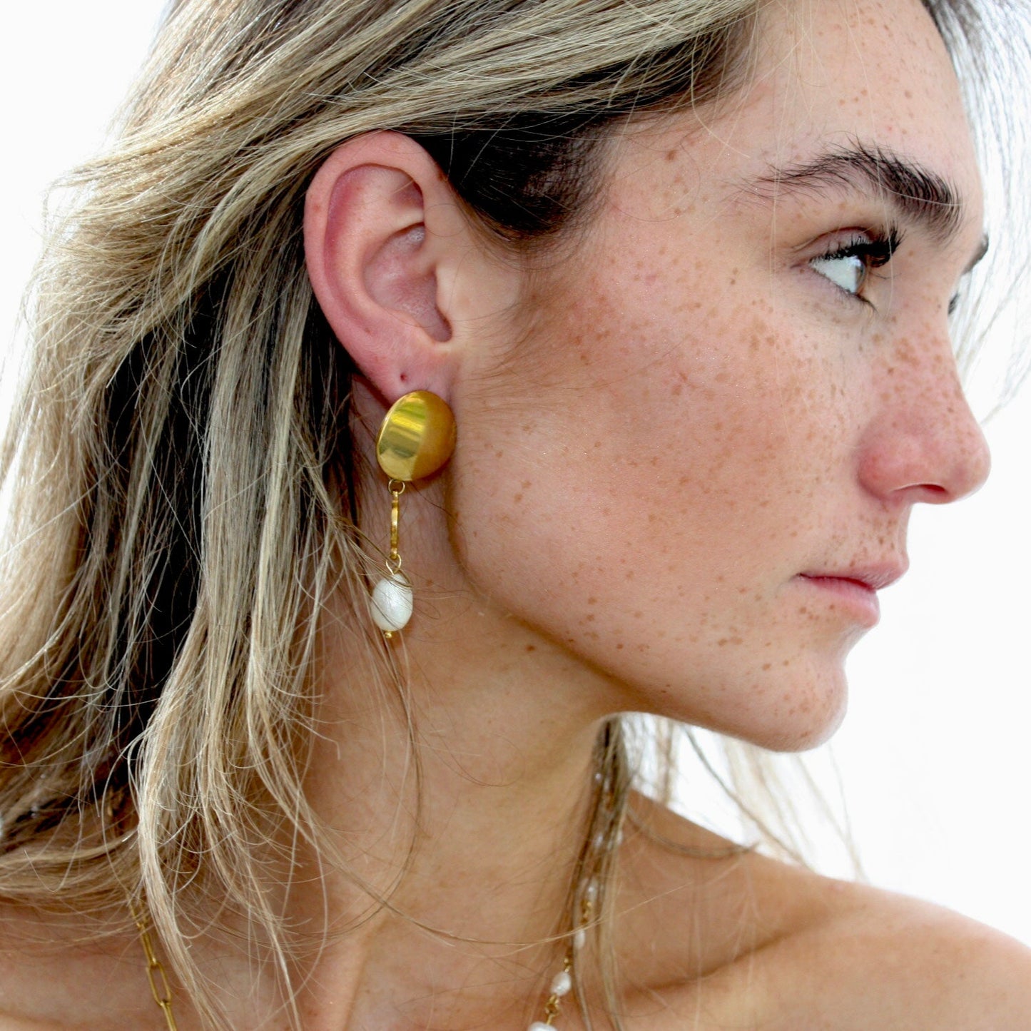 Close-up of chic pearl earrings in a modern design, highlighting the gold features and natural freshwater pearls, ideal for a trendy accessory.