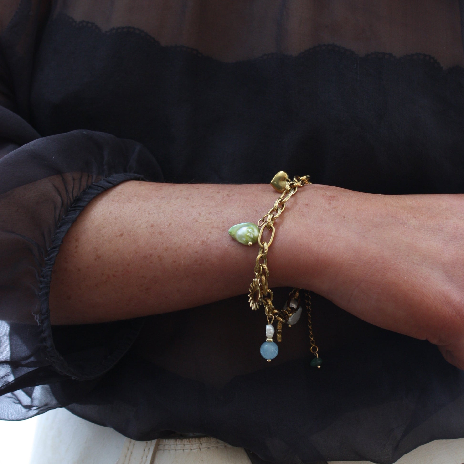 A close-up of a Custom Charm Bracelet featuring bright beads and unique shapes, elegantly worn on a wrist, perfect for everyday wear.