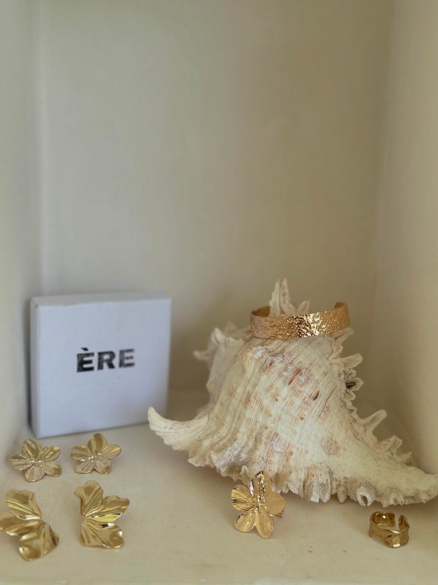 A lifestyle setup featuring the Aurora Ring by ÈRE among other accessories, emphasising its versatility and charm as an asymmetrical gold ring to elevate any outfit.