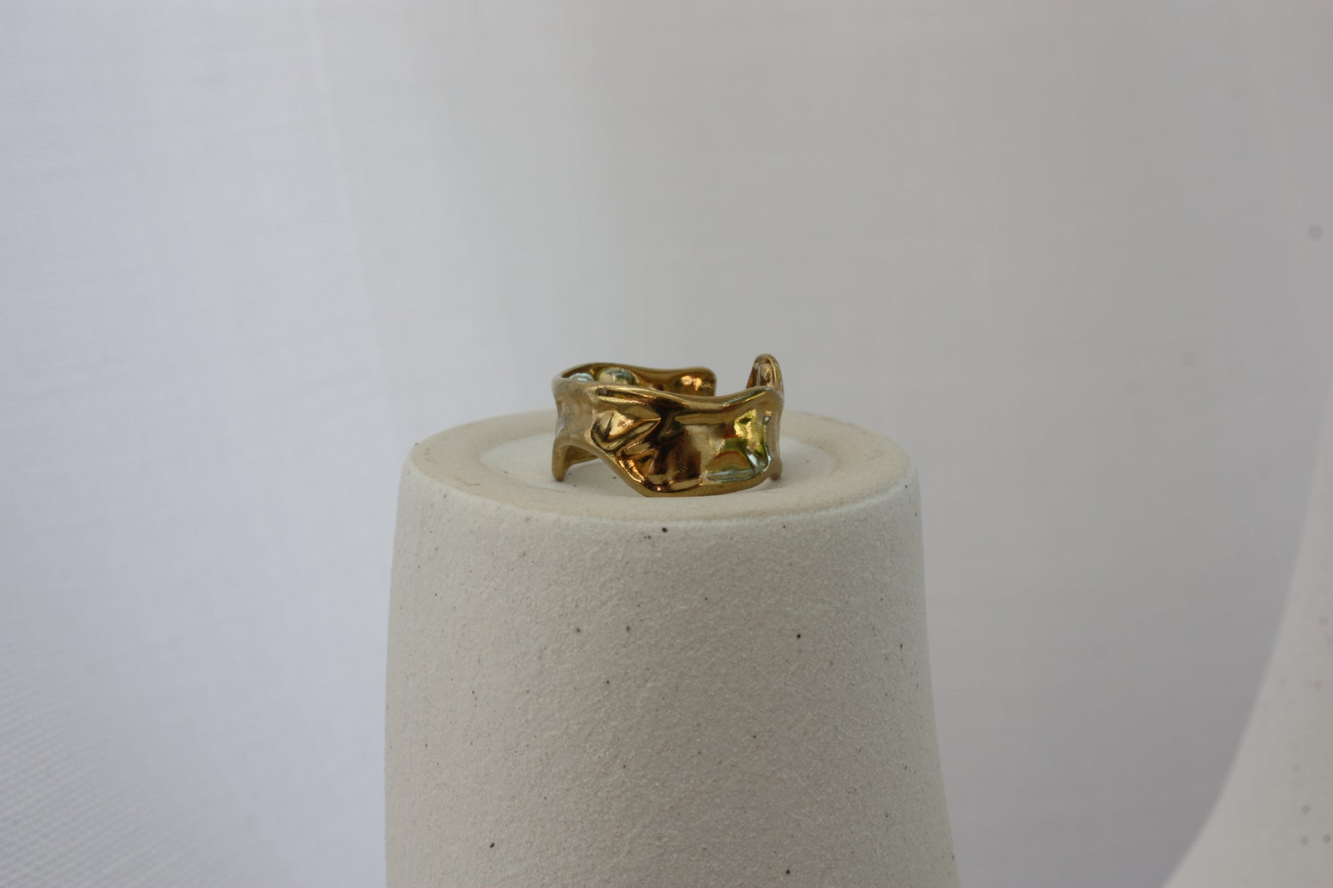 A detailed view of the Aurora Ring by ÈRE, showcasing the intricate hammered finish and asymmetrical style, making it a standout asymmetrical gold ring accessory.