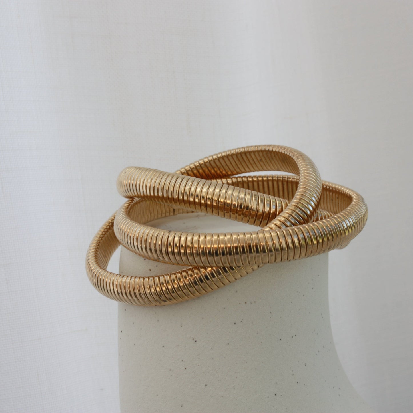 Stylish Rowe Bangle by ÈRE displayed on a minimalistic background, emphasising the stunning gold bangle's layered design.